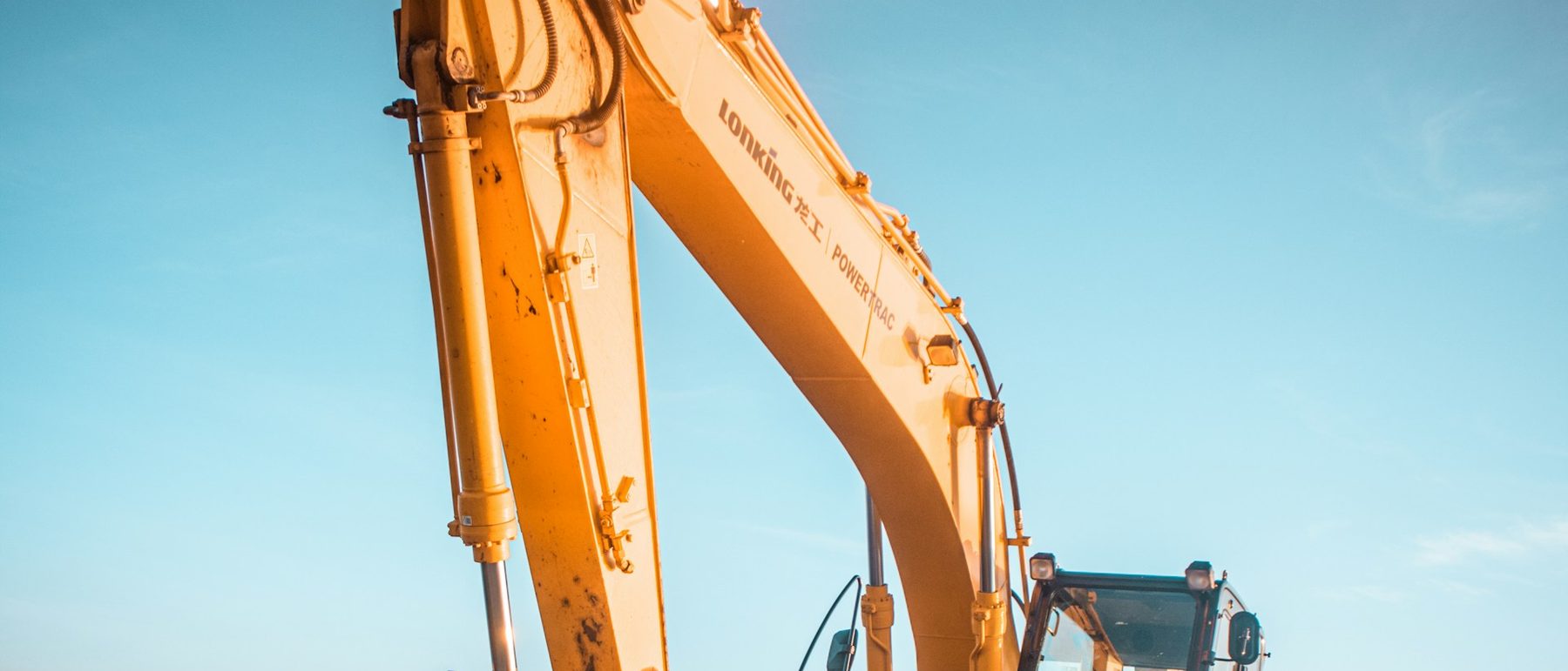 Excavator boom against an open sky