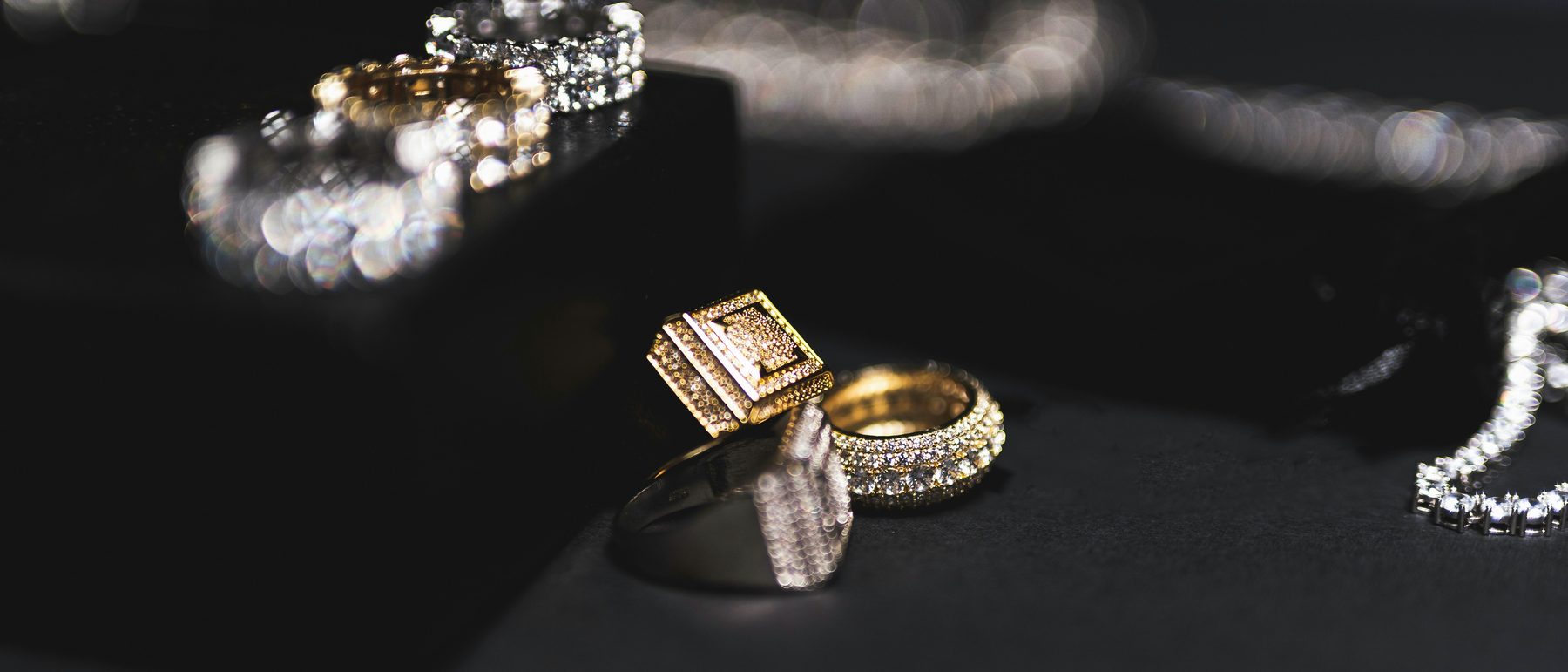 Diamond rings and a tennis bracelet on a dark display block